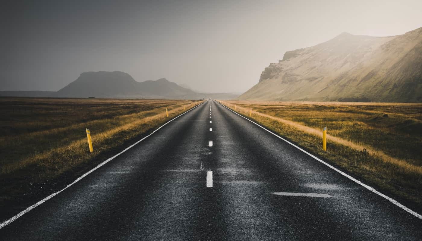 photo of an open road with mountains